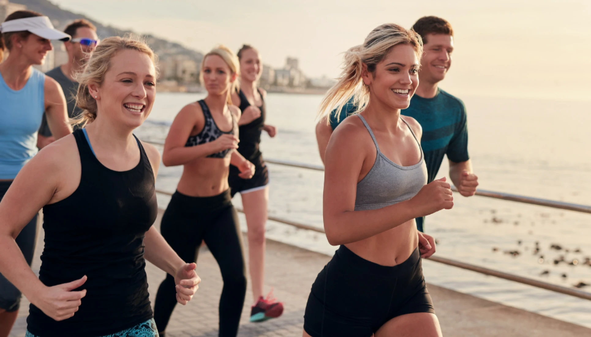 Group of people jogging together along a waterfront
